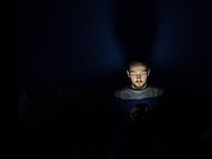 man using phone in the dark